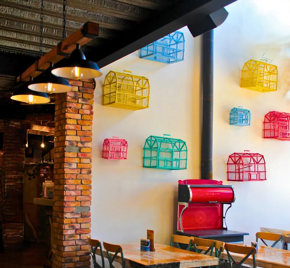 Comedor con jaulas de colores en la pared